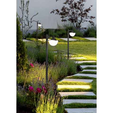 backyard of the mansion with a flowerbed and a lawn of green gra