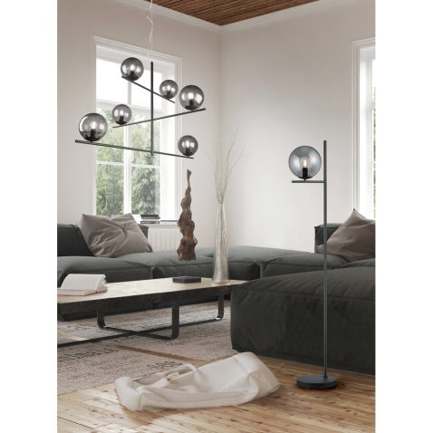 Two bare windows behind large black sofas
