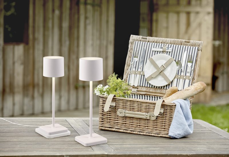 Open fitted wicker picnic hamper on a garden table